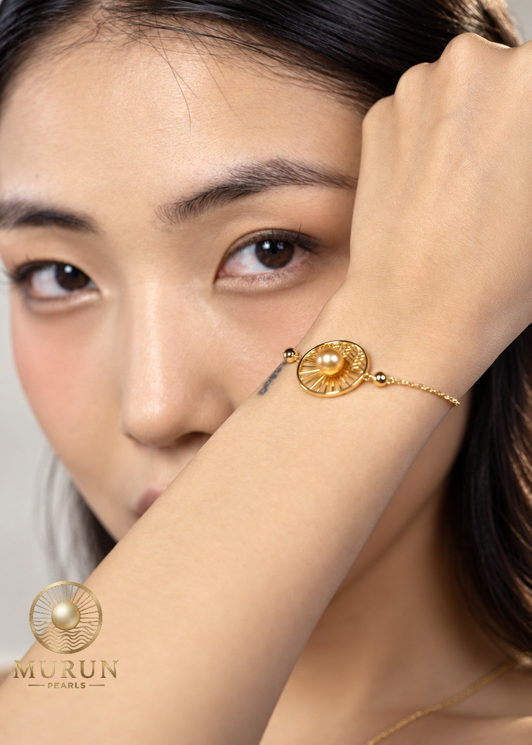 Murun Pearls Limited Edition emblem bracelet with a golden South Sea pearl on the wrist